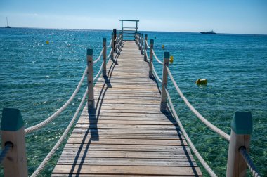 Saint-Tropez yakınlarındaki efsanevi Pampelonne plajındaki yatların misafirleri için ahşap iskele. Fransız Riviera, Fransa 'nın beyaz kumlu sahillerinde yaz tatili.