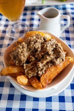 İskoç geleneksel abur cubur, patates cipsi üzerine yahni ve sos, Edinburgh, İskoçya 'da eski meyhanede servis edilir.