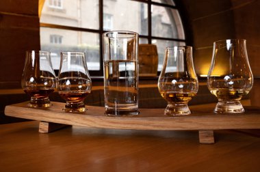 Flight of single malt scotch whisky in glasses served in bar in Edinburgh, UK, tasting of dram of whiskey