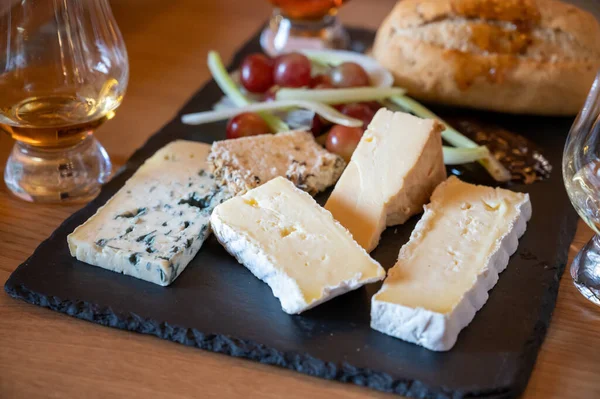 Pairing of scotch whiskies and farmers scottish cheeses cheddar, stilton, blue cheese, brie, tasting of whiskey and cheese in Edinburgh, UK