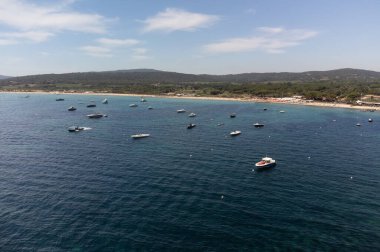 Saint-Tropez yakınlarındaki efsanevi Pampelonne plajı ve mavi deniz manzarası Fransız Rivierası 'nın beyaz kumlu sahillerinde yaz tatili.