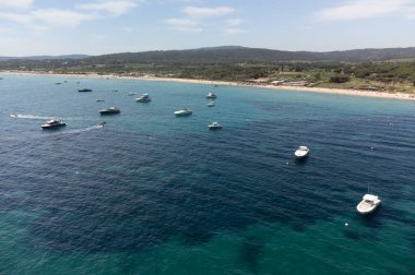 Saint-Tropez yakınlarındaki efsanevi Pampelonne plajı ve mavi deniz manzarası Fransız Rivierası 'nın beyaz kumlu sahillerinde yaz tatili.