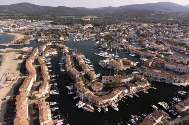 Aerial view on blue water of Gulf of Saint-Tropez, sail boats, houses of Port Grimaud and Port Cogolin, summer vacation in Provence, France