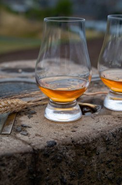 Tasting of single malt scotch whisky in glasses with panoramic view from Calton hill to new and old parts of Edinburgh city in rainy summer day, Scotland, UK