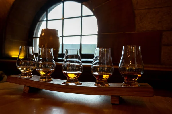 Flight of single malt scotch whisky in glasses served in bar in Edinburgh, UK, tasting of dram of whiskey