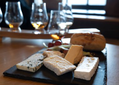 Pairing of scotch whiskies and farmers scottish cheeses cheddar, stilton, blue cheese, brie, tasting of whiskey and cheese in Edinburgh, UK