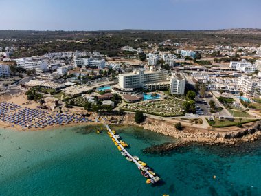Villalar, tatil beldeleri ve Akdeniz 'deki kumlu incir ağacı plajı, Protaras, Kıbrıs Rum Kesimi yakınlarındaki mavi kristal berrak su üzerindeki hava panoramik manzarası