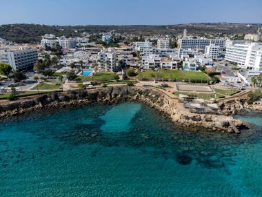 Villalar, tatil beldeleri ve Akdeniz 'deki kumlu incir ağacı plajı, Protaras, Kıbrıs Rum Kesimi yakınlarındaki mavi kristal berrak su üzerindeki hava panoramik manzarası