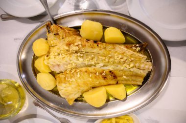 Portekiz 'de balık lokantasında patates ile servis edilen kızarmış morina balığı filetosu.