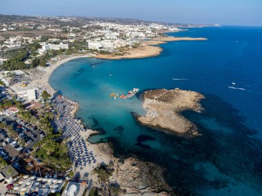 Kıbrıs Rum Kesimi 'nin Ayia Napa plajı yakınlarındaki Akdeniz' de tatil villaları ve tatil beldelerinde havadan panoramik manzara ve mavi kristal berrak su. Deniz tatili.