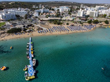 Villalar, tatil beldeleri ve Akdeniz 'deki kumlu incir ağacı plajı, Protaras, Kıbrıs Rum Kesimi yakınlarındaki mavi kristal berrak su üzerindeki hava panoramik manzarası