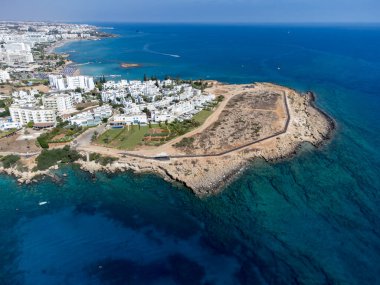 Villalar, tatil beldeleri ve Akdeniz 'deki kumlu incir ağacı plajı, Protaras, Kıbrıs Rum Kesimi yakınlarındaki mavi kristal berrak su üzerindeki hava panoramik manzarası