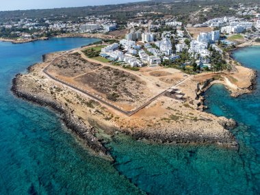 Villalar, tatil beldeleri ve Akdeniz 'deki kumlu incir ağacı plajı, Protaras, Kıbrıs Rum Kesimi yakınlarındaki mavi kristal berrak su üzerindeki hava panoramik manzarası
