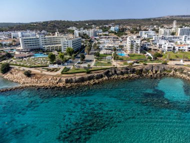 Villalar, tatil beldeleri ve Akdeniz 'deki kumlu incir ağacı plajı, Protaras, Kıbrıs Rum Kesimi yakınlarındaki mavi kristal berrak su üzerindeki hava panoramik manzarası
