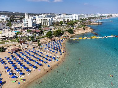 Villalar, tatil beldeleri ve Akdeniz 'deki kumlu incir ağacı plajı, Protaras, Kıbrıs Rum Kesimi yakınlarındaki mavi kristal berrak su üzerindeki hava panoramik manzarası