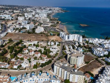 Villalar, tatil beldeleri ve Akdeniz 'deki kumlu incir ağacı plajı, Protaras, Kıbrıs Rum Kesimi yakınlarındaki mavi kristal berrak su üzerindeki hava panoramik manzarası