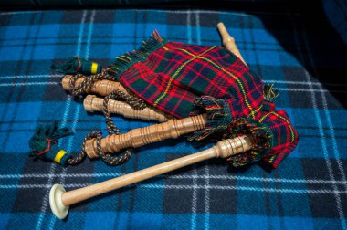 Symbols of Scotland - wollen tartan textile and handmade musical instrument bagpipes, close up