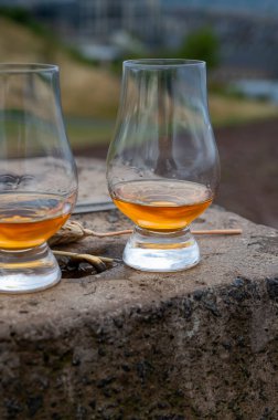 Tasting of single malt scotch whisky in glasses with panoramic view from Calton hill to new and old parts of Edinburgh city in rainy summer day, Scotland, UK