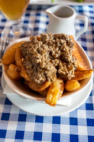 İskoç geleneksel abur cubur, patates cipsi üzerine yahni ve sos, Edinburgh, İskoçya 'da eski meyhanede servis edilir.