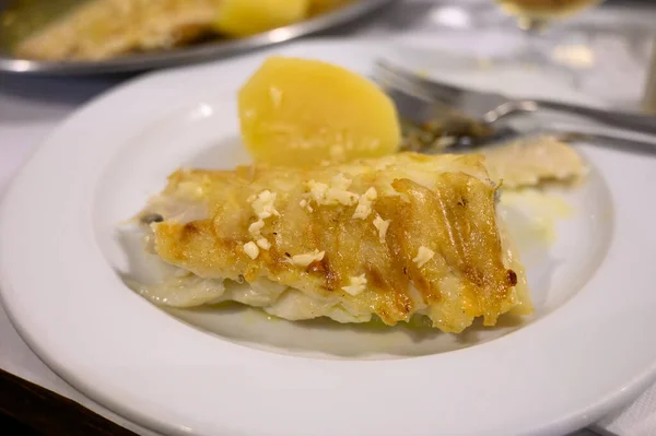 ポルトガルの魚料理店でジャガイモを添えて提供される白コードフィッシュバカラのグリルフィレ — ストック写真