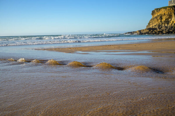 Пляж Магоито на берегу Атлантического океана, красивый песчаный пляж на побережье Синтры, район Лисбон, Португалия, часть природного парка Синтра-Кашкайш с природными достопримечательностями