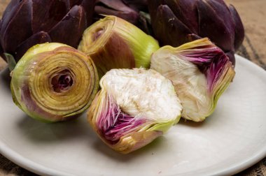 Çiğ taze mor Romanesco enginar kafaları sebze kafaları ve pişirmeye hazır haplanmış kalpler.