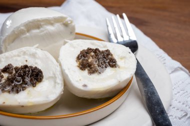 Beyaz İtalyan yumuşak peyniri Mozzarella di Bufala Campana siyah mantarla doldurulmuş.