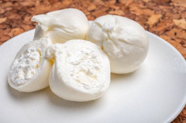 Puglia 'dan taze el yapımı İtalyan peyniri yemek, beyaz burrata topları veya mozzarella ve kremadan yapılmış burratina peyniri yemek.