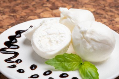 Puglia 'dan taze el yapımı yumuşak İtalyan peyniri yemek, beyaz burrata topları veya mozzarella ve krem ile kaplanmış burratina peyniri.