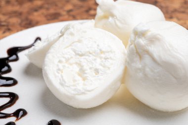 Puglia 'dan taze el yapımı yumuşak İtalyan peyniri yemek, beyaz burrata topları veya mozzarella ve krem ile kaplanmış burratina peyniri.