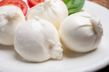 Puglia 'dan taze el yapımı İtalyan peyniri yemek, beyaz burrata topları veya mozzarella ve kremadan yapılmış burratina peyniri yemek.