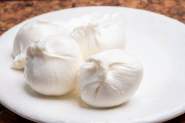 Puglia 'dan taze el yapımı İtalyan peyniri yemek, beyaz burrata topları veya mozzarella ve kremadan yapılmış burratina peyniri yemek.