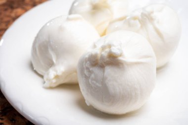 Puglia 'dan taze el yapımı İtalyan peyniri yemek, beyaz burrata topları veya mozzarella ve kremadan yapılmış burratina peyniri yemek.