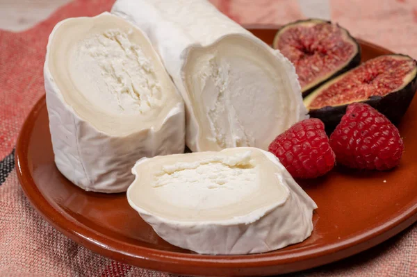 フランスの有機成熟した白ヤギチーズと白カビのクローズアップ新鮮なラズベリーとイチジクを添えています — ストック写真