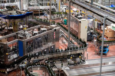 Burgundy, Fransa 'da kremant köpüklü şarap üretimi. Fabrikadaki otomatik güç şişeleme ve mantar hatları.