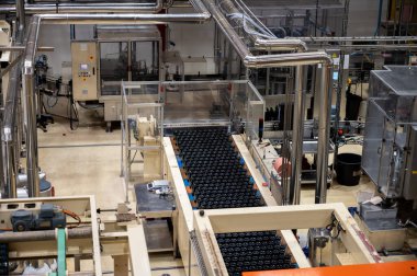 Burgundy, Fransa 'da kremant köpüklü şarap üretimi. Fabrikadaki otomatik güç şişeleme ve mantar hatları.