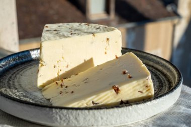 Aromatik siyah kimyon tohumlu beyaz koyun peyniri. Açık havada servis ediliyor.