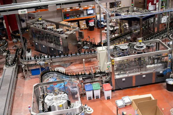 stock image Production of cremant sparkling wine in Burgundy, France. Automatically powered bottling and corking lines on factory.