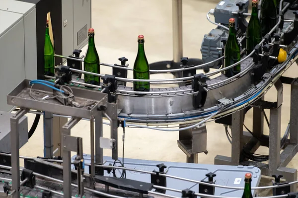 Production of cremant sparkling wine in Burgundy, France. Automatically powered bottling, corking, packaging lines on factory.