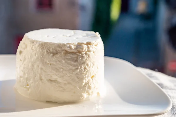 法国软绵绵的白山羊奶酪在旧城的户外阳光下供应 — 图库照片