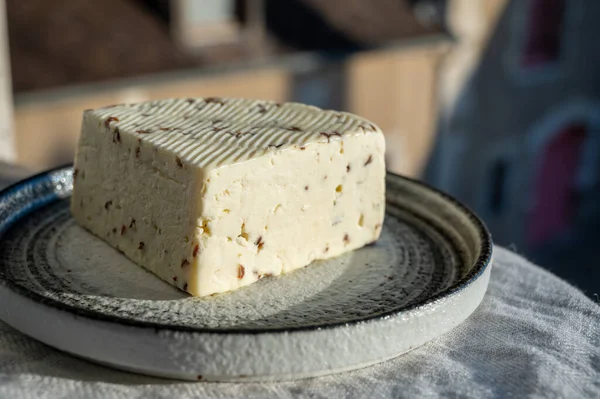 stock image Piece of white sheep cheese with aromatic black cumin seeds served outdoor