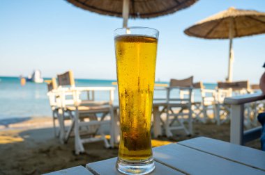 Kıbrıs 'taki güneşli sahil barında bira servis ediliyor.