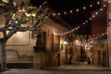Gece vakti Elciego köyünün eski dar ortaçağ sokaklarında Noel ışıklarıyla aydınlatılmış Rioja Alavesa, İspanya
