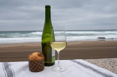 Tatlı meyve Noel 'i ve yeni yıl pastası panettone' u iki bardak txakoli beyaz şarap ile Bakio, Bask ülkesinde kumlu plajda servis edilir.