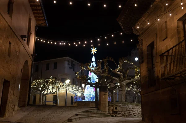 Walking at night on old narrow medieval streets of Elciego village illuminated with Christmas lights, Rioja Alavesa, Spain