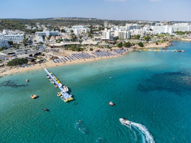 Villalar, tatil beldeleri ve Akdeniz 'deki kumlu incir ağacı plajı, Protaras, Kıbrıs Rum Kesimi yakınlarındaki mavi kristal berrak su üzerindeki hava panoramik manzarası