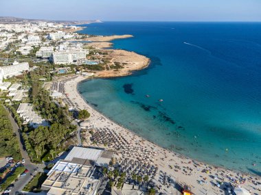 Kıbrıs Rum Kesimi 'nin Ayia Napa plajı yakınlarındaki Akdeniz' de tatil villaları ve tatil beldelerinde havadan panoramik manzara ve mavi kristal berrak su. Deniz tatili.