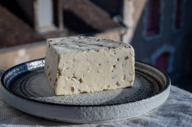 Aromatik siyah kimyon tohumlu beyaz koyun peyniri. Açık havada servis ediliyor.