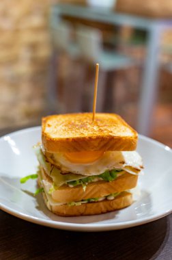 Beyaz ekmek, yumurta, yeşil marul ve peynirli vejetaryen sandviç.