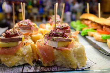 Bask ülkesinin tipik aperatiflerine sahip beyaz tahta, küçük ekmek parçaları, kabak, deniz ürünü, yumurta, peynir içeren pinkhos veya pinktos şişleri, San Sebastian veya Bilbao, İspanya 'da barda servis edilir.